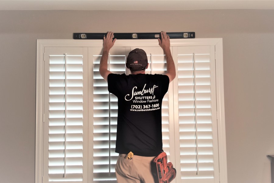 Professional installing plantation shutters.